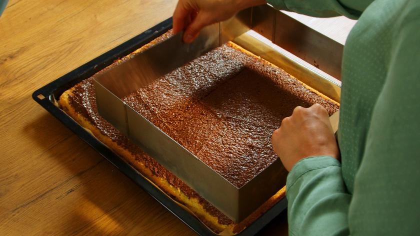 Um den Boden der Himbeer-Quark-Torte wird ein Backrahmen gespannt.