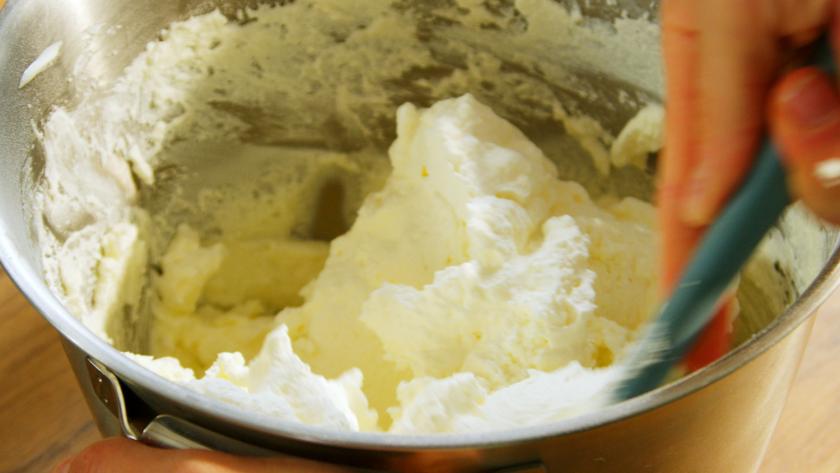 Quark wird mit Sahne in einer Schüssel verrührt.