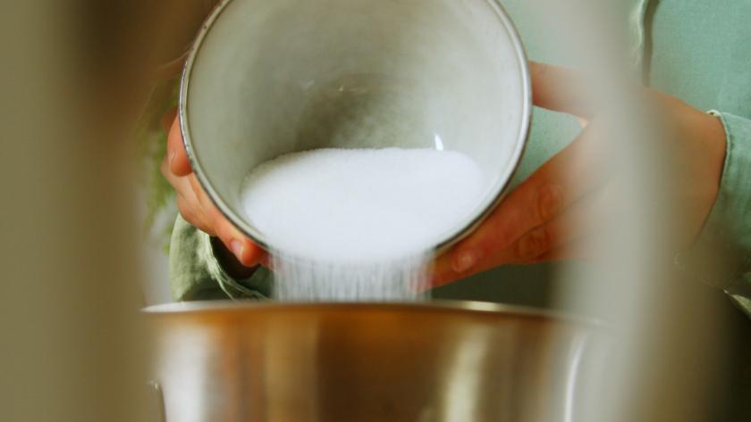 Zucker wird in eine Rührschüssel gegeben.