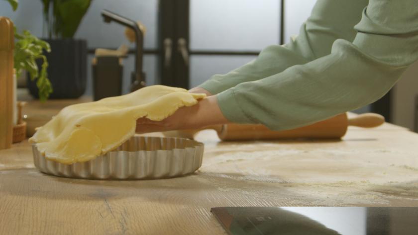 Teig wird in die Form eingepasst.