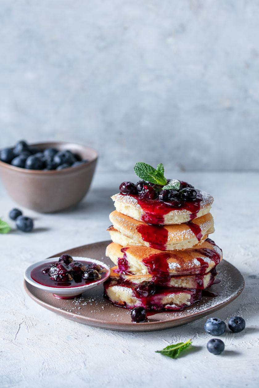 Japanische Pancakes mit Heidelbeerkompott übereinander gestapelt.