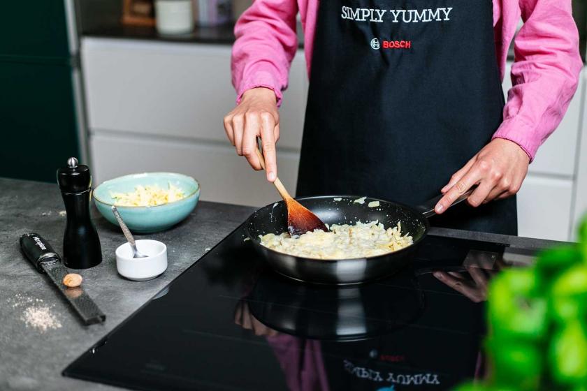 Käsespätzle werden in einer Pfanne erhitzt.