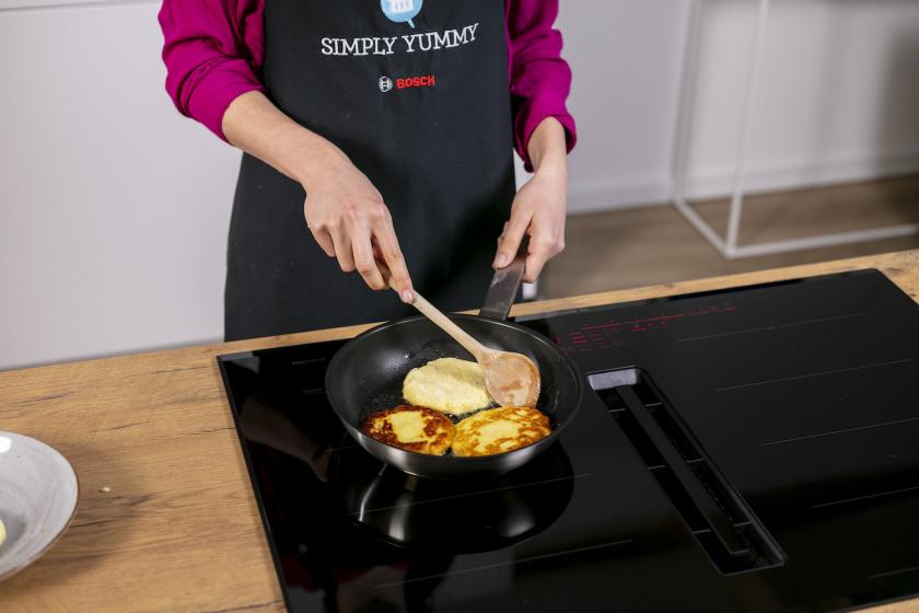 Kartoffelpuffer aus gekochten Kartoffeln werden in einer Pfanne gebraten.