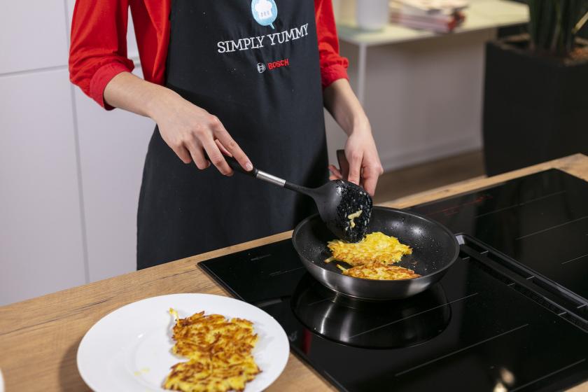 Kartoffelpuffer nach Grundrezept werden in einer Pfanne gebraten.