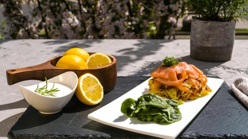 Kartoffelpuffer mit Lachs auf einem Teller angerichtet.