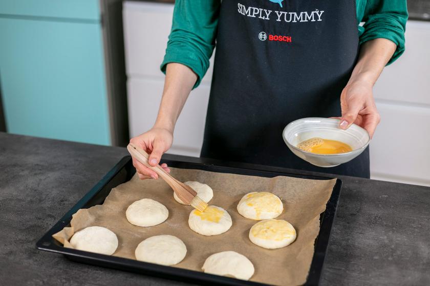 Käsebrötchen werden mit Ei bestrichen.
