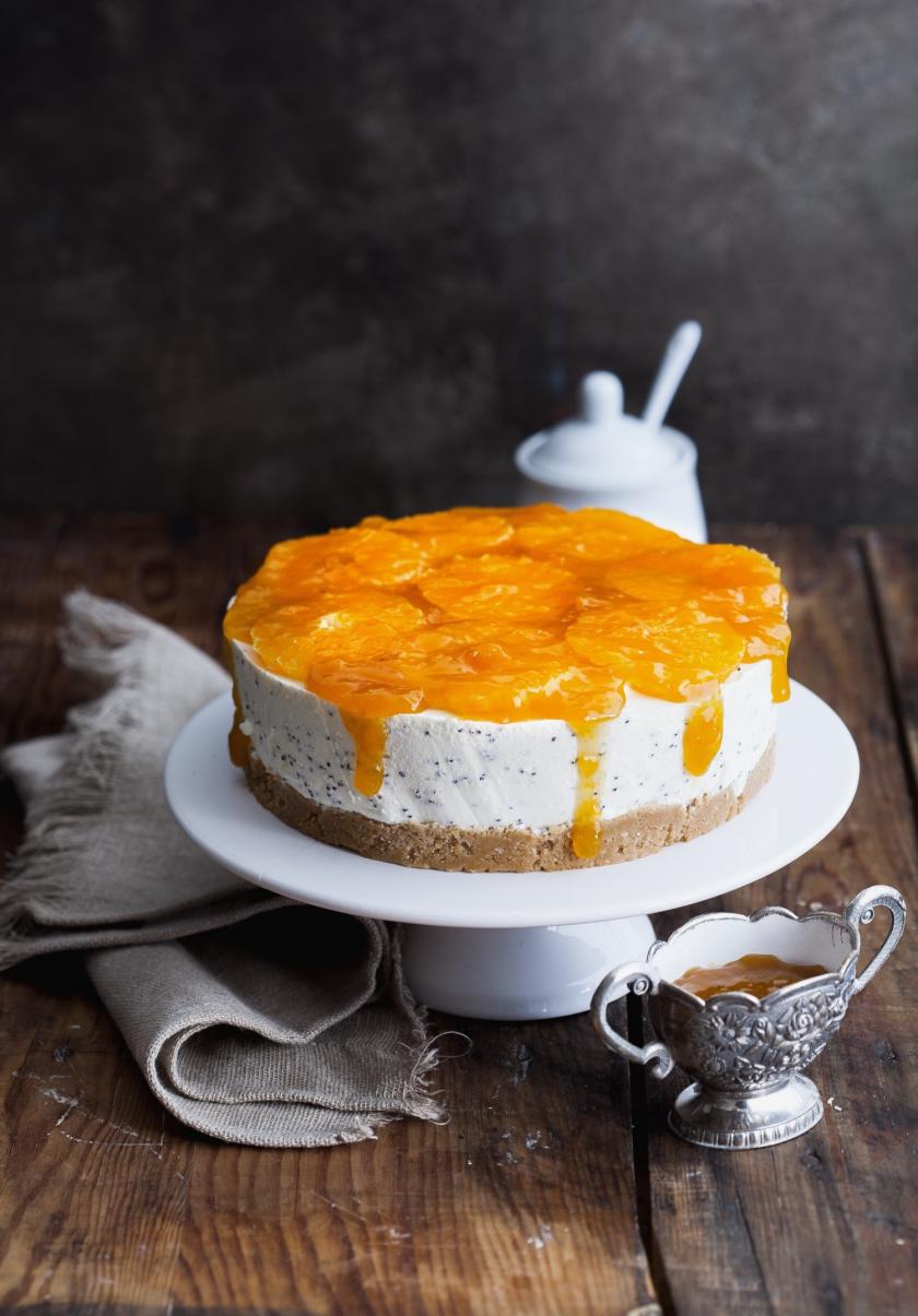 Joghurttorte mit Mandarinen auf weißer Tortenplatte.