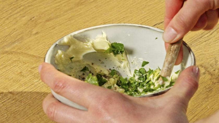 Kräuterbutter wird in einer Schale verrührt.