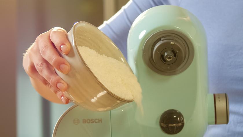 Kokosraspeln werden in die Schüssel einer Küchenmaschine gegeben.