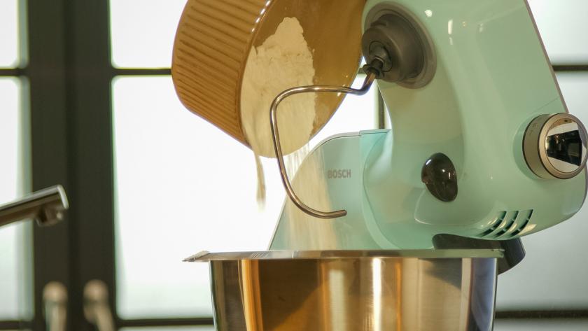 Mehl wird in die Rührschüssel einer Küchenmaschine gegeben.