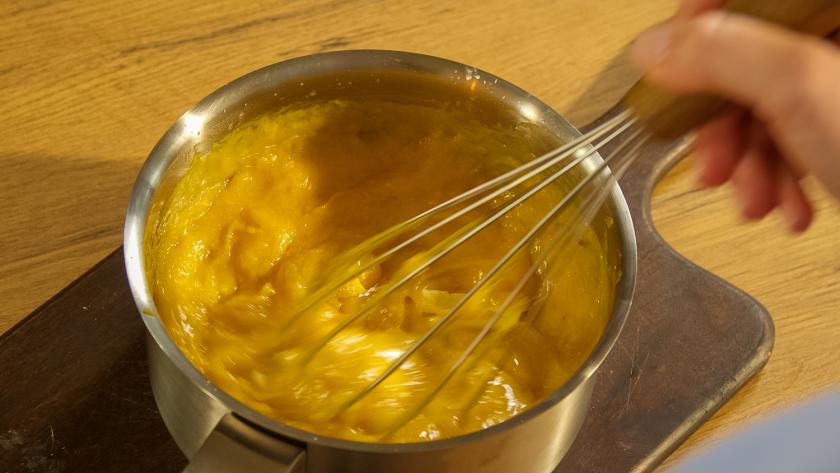 Maracuja Curd für Kokos-Pie wird in einem Topf gerührt.