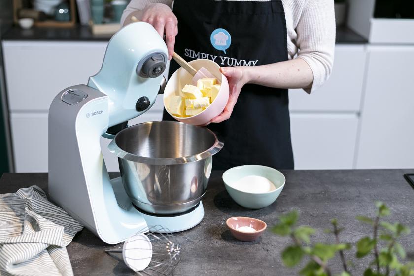 Butter wird in die Rührschüssel einer Küchenmaschine gegeben.