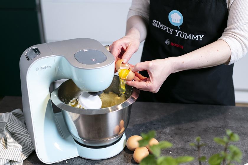 Eier werden in die Rührschüssel einer Küchenmaschine zum Teig gegeben.