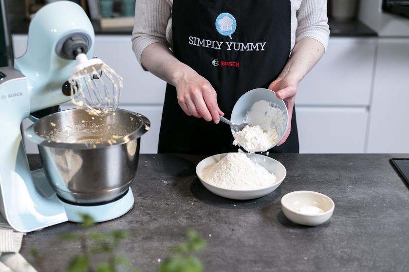 Mehl wird mit Backpulver und Natron auf einem Teller vermischt.