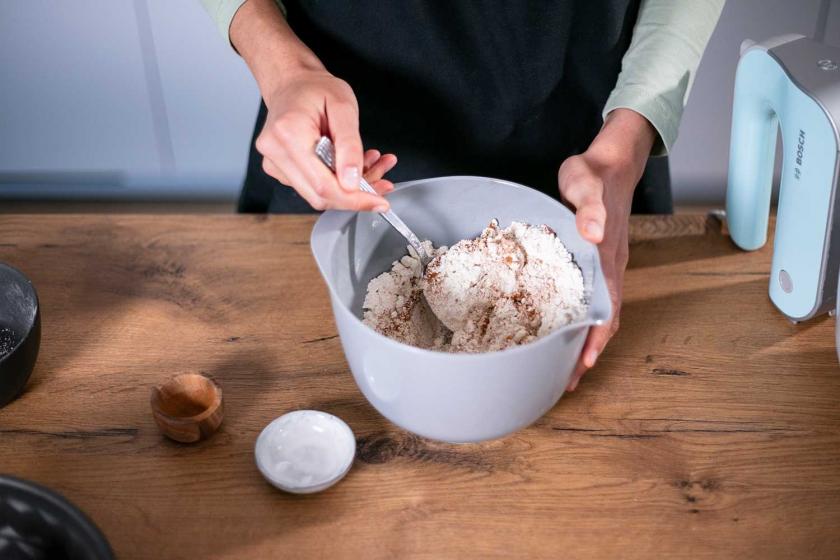 Trockene Zutaten für den Teig des Kürbiskuchen ohne Zucker werden in einer Schüssel vermengt.