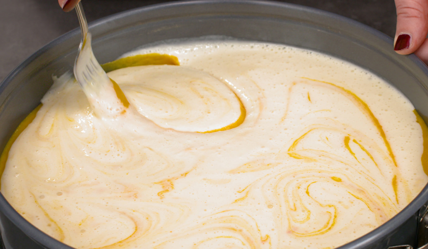 Für den Kürbiskuchen mit Cheesecakeswirl wird die Frischkäsemasse verteilt.