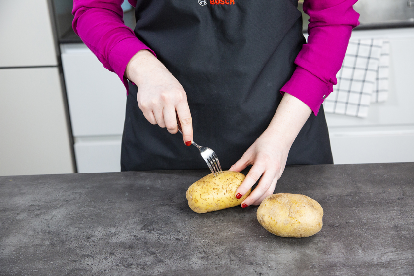 Die Kumpir wird rundherum mit einer Gabel eingestochen.
