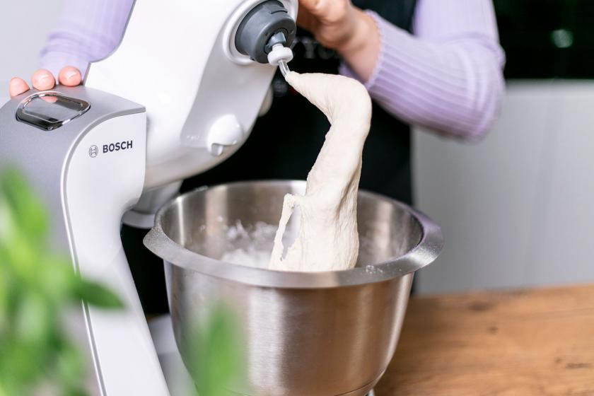 Teig für Langos ist in der Rührschüssel einer Küchenmaschine.