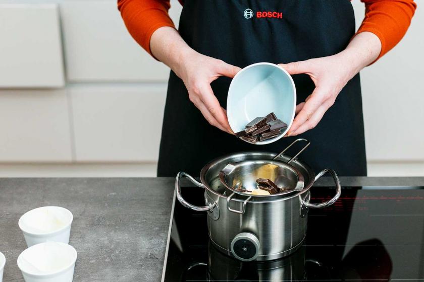 Schokolade wird in eine Schüssel über einem Wasserbad gegeben.