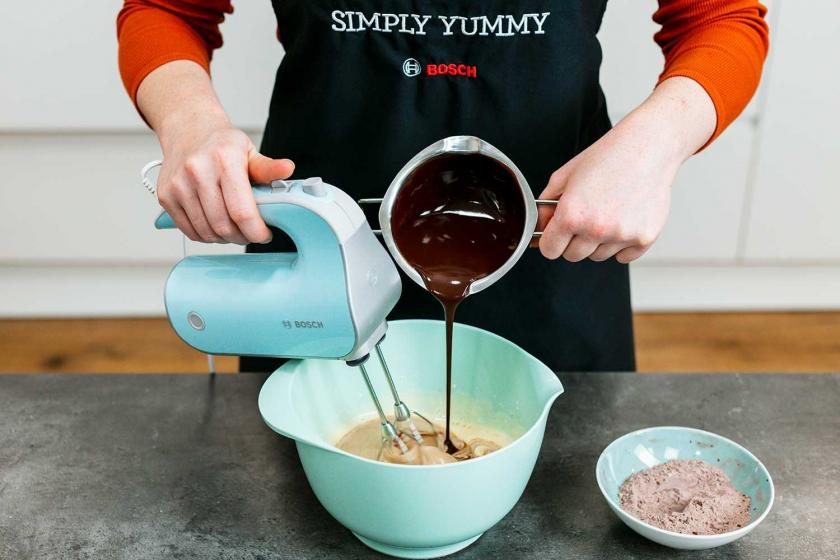 Schokolade wird zum Teig für den Lava Cake gegeben und mit einem Mixer verrührt.