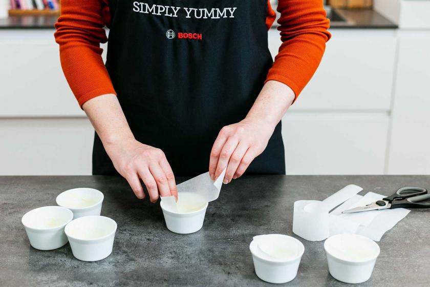 Die Backförmchen für den Lava Cake werden mit Backpapier ausgelegt.