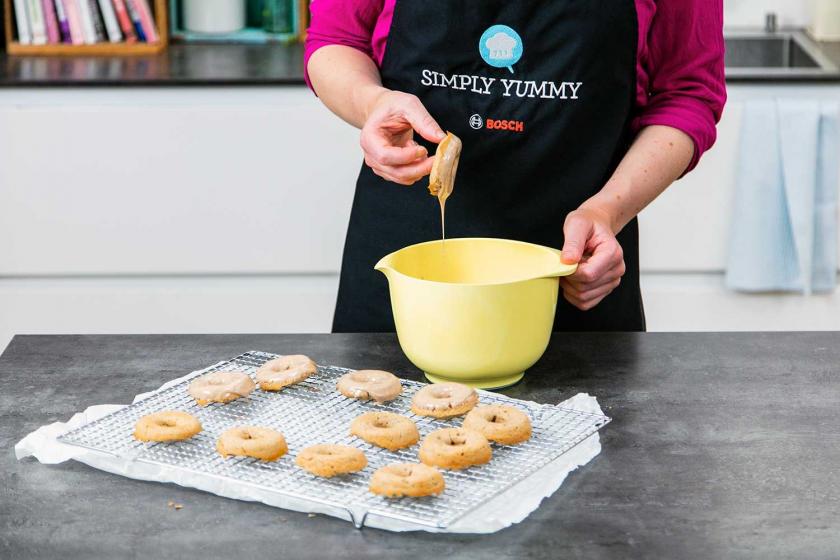 Lebkuchen-Donuts werden in die Glasur getunkt.