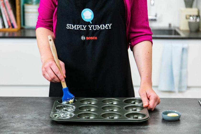 Backform für die Lebkuchen-Donuts wird eingefettet.