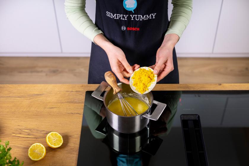 Zitronenschale wird zu geschmolzener Butter in einen Topf gegeben.