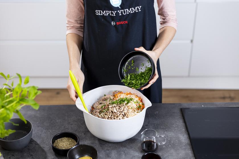 Petersilie wird zur Masse für den Linsenbraten in eine Schüssel gegeben.