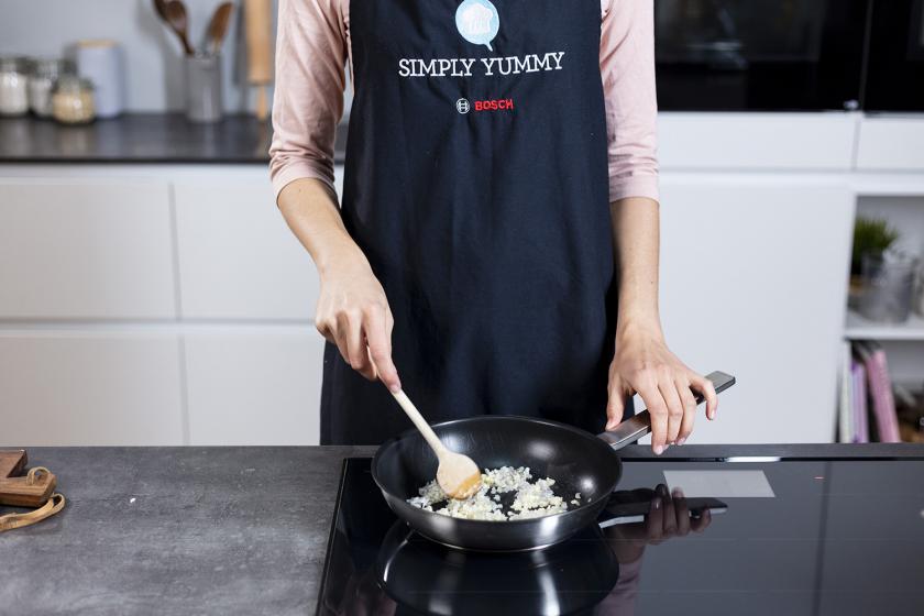 Zwiebel und Knoblauch werden in einer Pfanne angebraten.