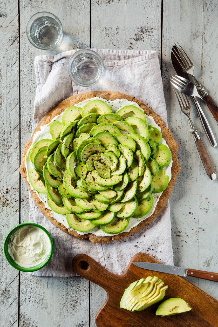 Low Carb Avocado Pizza auf einem Tuch angerichtet.