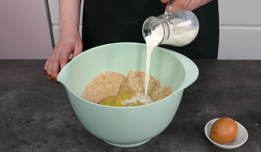 Zum Teig der Low Carb Avocado Pizza wird Milch in eine Schüssel gegossen.