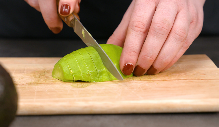 Für die Low Carb Avocado Pizza wird Avocado geschnitten.