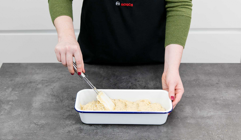 Der Teig für den Low Carb Zitronenkuchen mit Chia-Samen wird in einer Kastenform glatt gestrichen.
