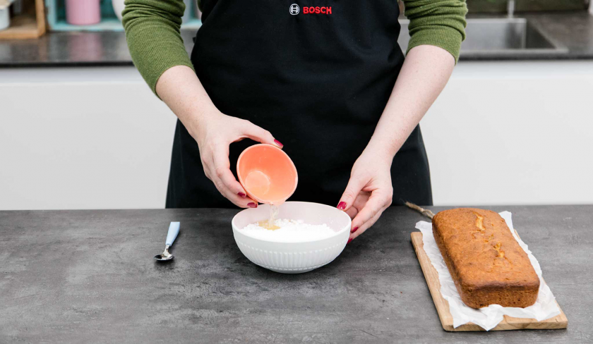 Für den Guss für den Low Carb Zitronenkuchen mit Chia-Samen wird Zitronensaft zu Puder-Erythrit gegeben.