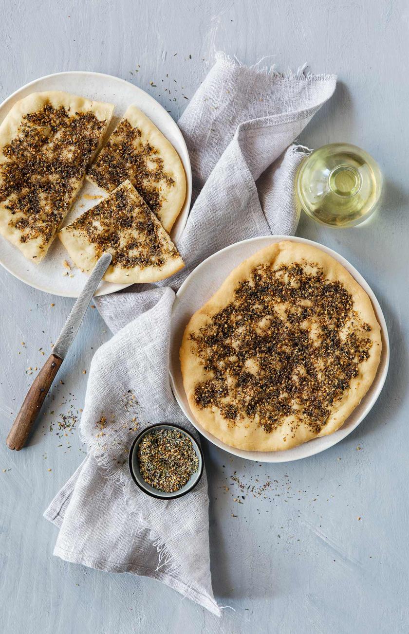 Zwei Manakish mit Zatarr auf Tellern.