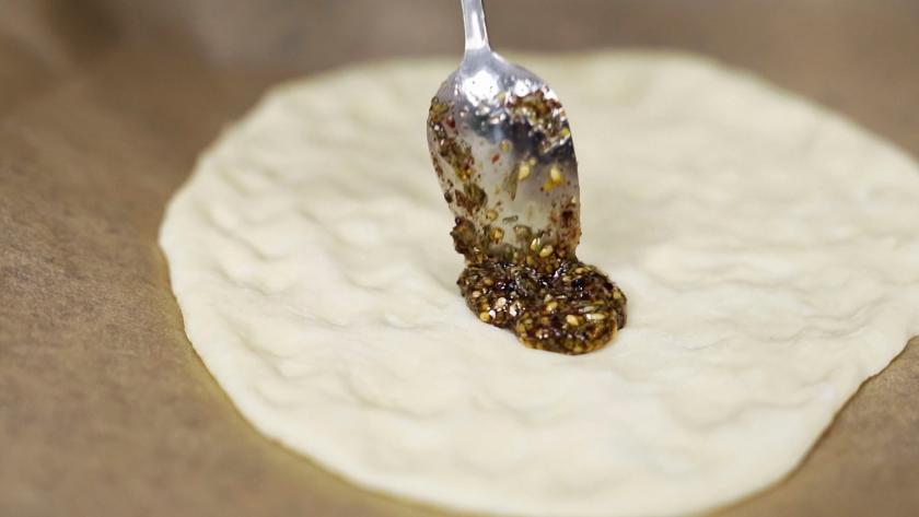 Zatar wird auf den Manakish verteilt.