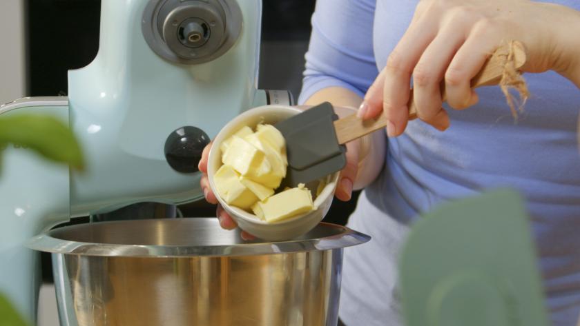 Butter wird in die Rührschüssel einer Küchenmaschine gegeben.