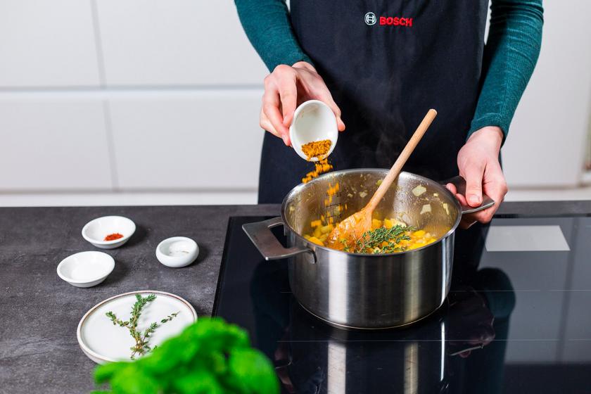 Currypulver wird in den Topf zum Mango Chutney gegeben.