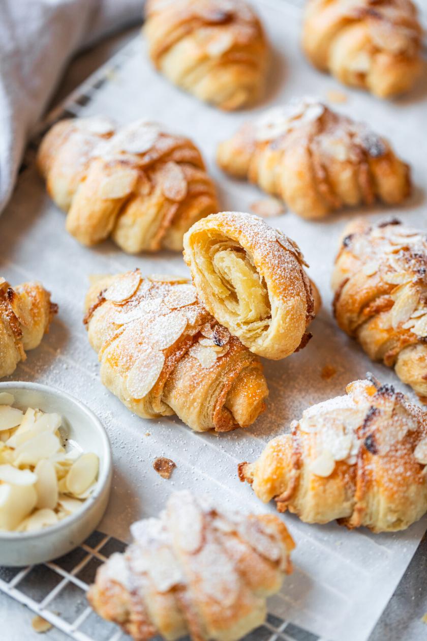 Marzipan Croissants auf einem Backblech, bestäubt mit Puderzucker