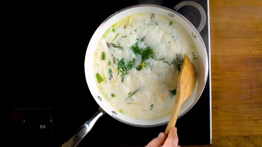 Pfanne auf Herd, in der Spargelragout gekocht wird.