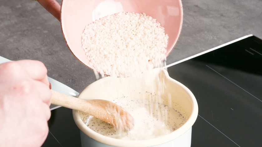 Für den Teig der Milchreis-Brownies wird Reis in die erhitzte Milch eingerührt.