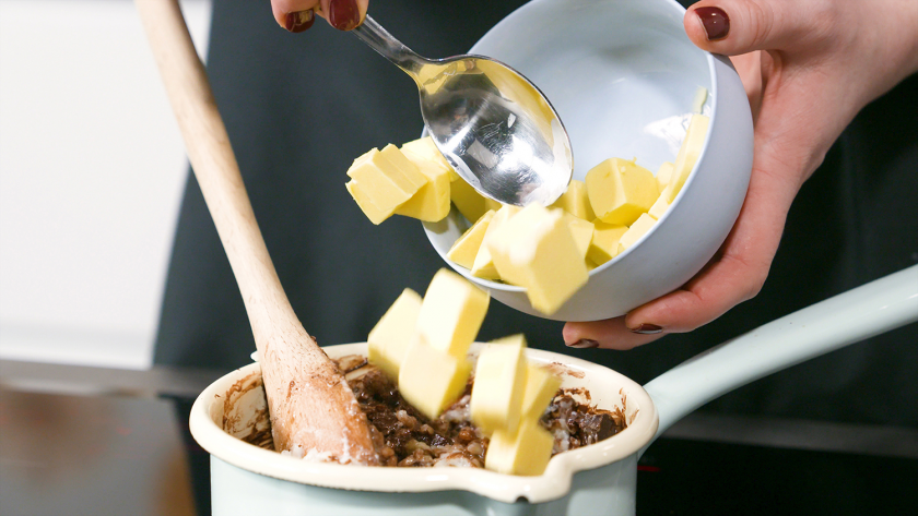 Zum Milchreis für die Milchreis-Brownies wird gewürfelte Butter gegeben.