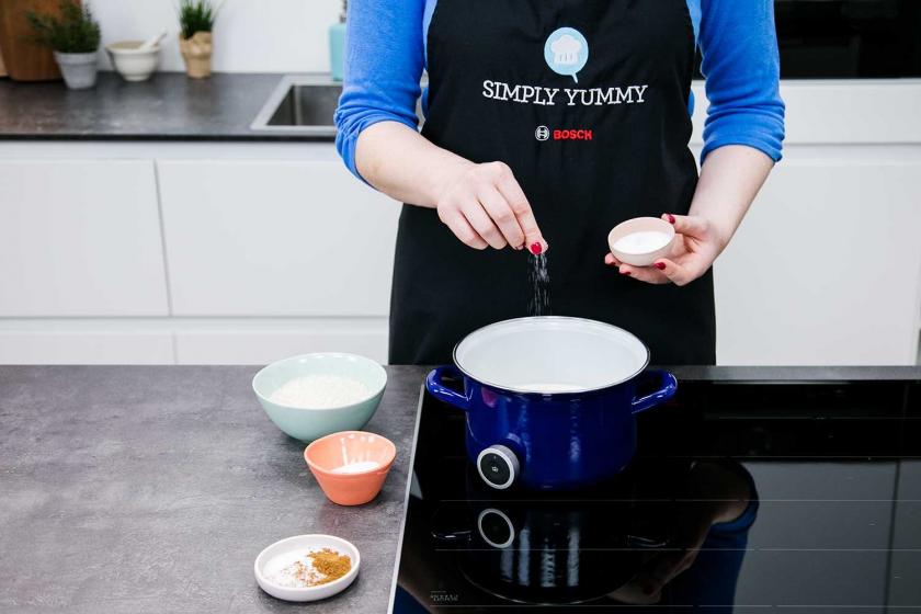 Salz wird zur Milch in einem Topf gegeben.