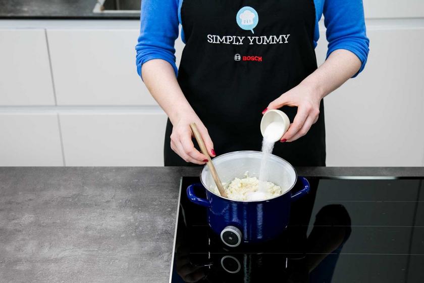 Zucker wird zum Milchreis in den Topf gegeben.