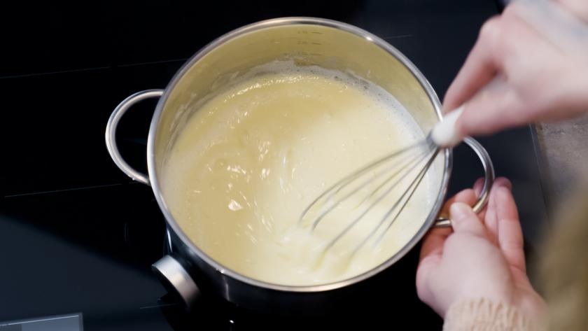 Vanillepudding wird in einem Topf gekocht.