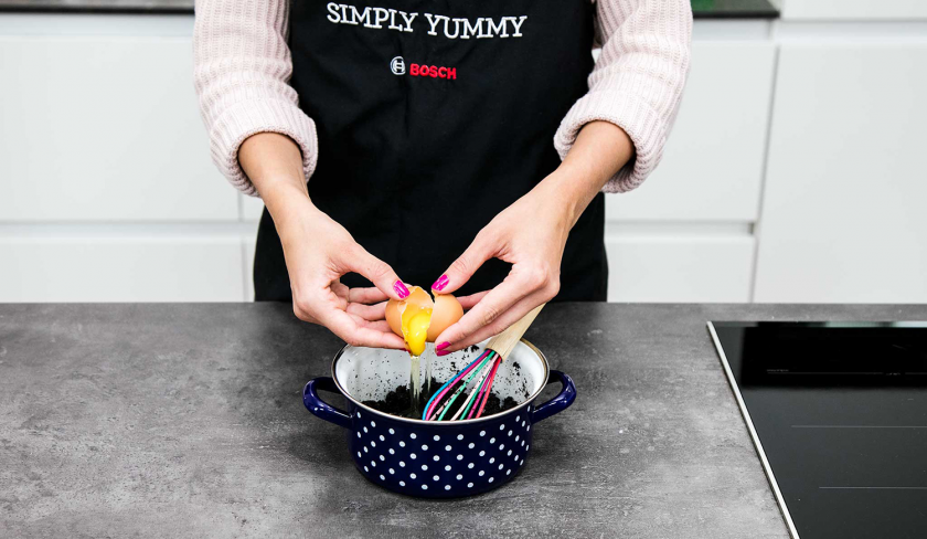 Ein Ei wird in die Füllung der Mohnschnecke gegeben.