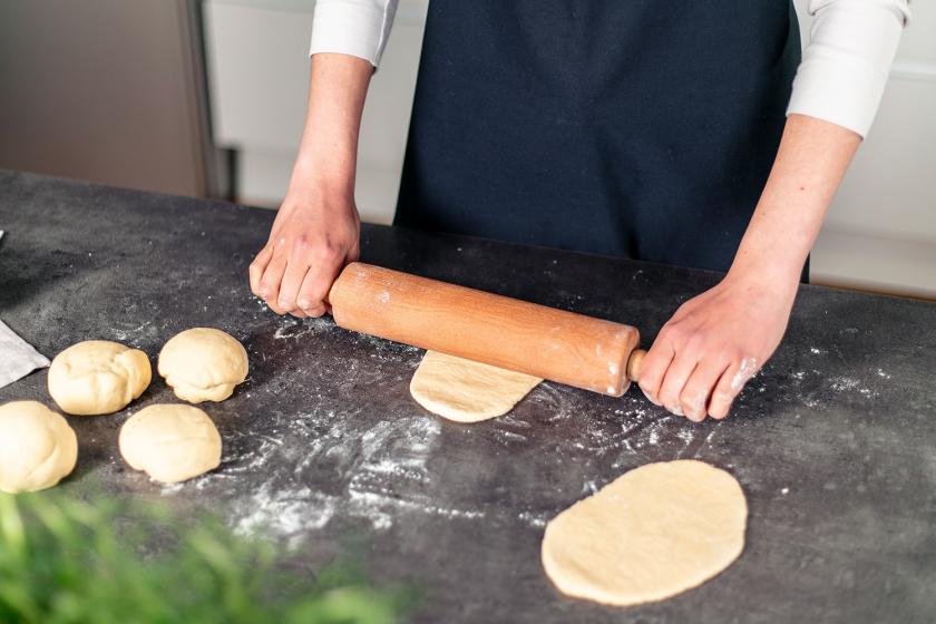 Naan Brot Teiglinge werden ausgerollt.