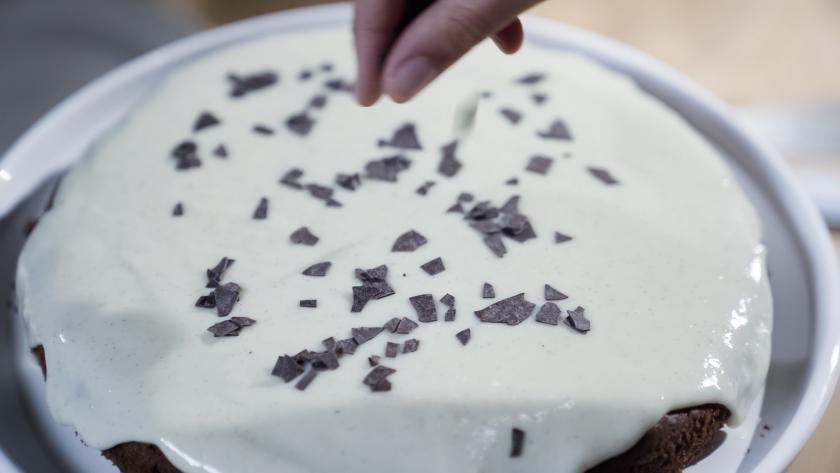 Schokostreusel werden auf dem Nuss-Pudding-Kuchen verteilt.