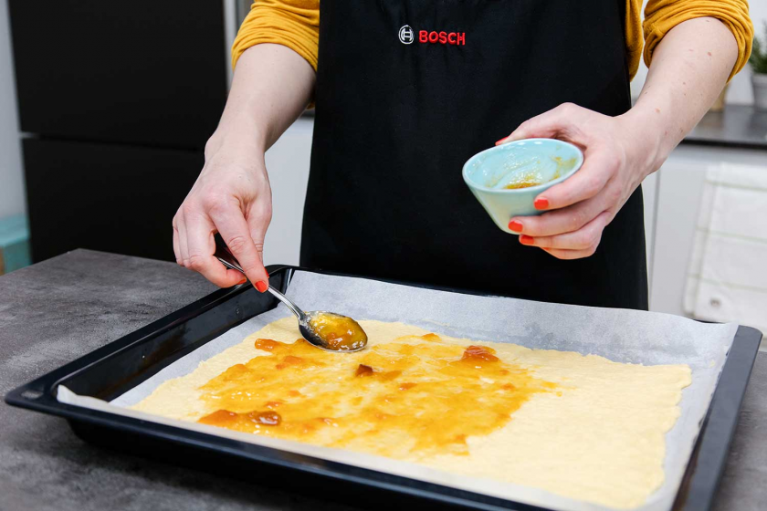 Auf den Boden der Nussecken wird Aprikosenmarmelade gestrichen.